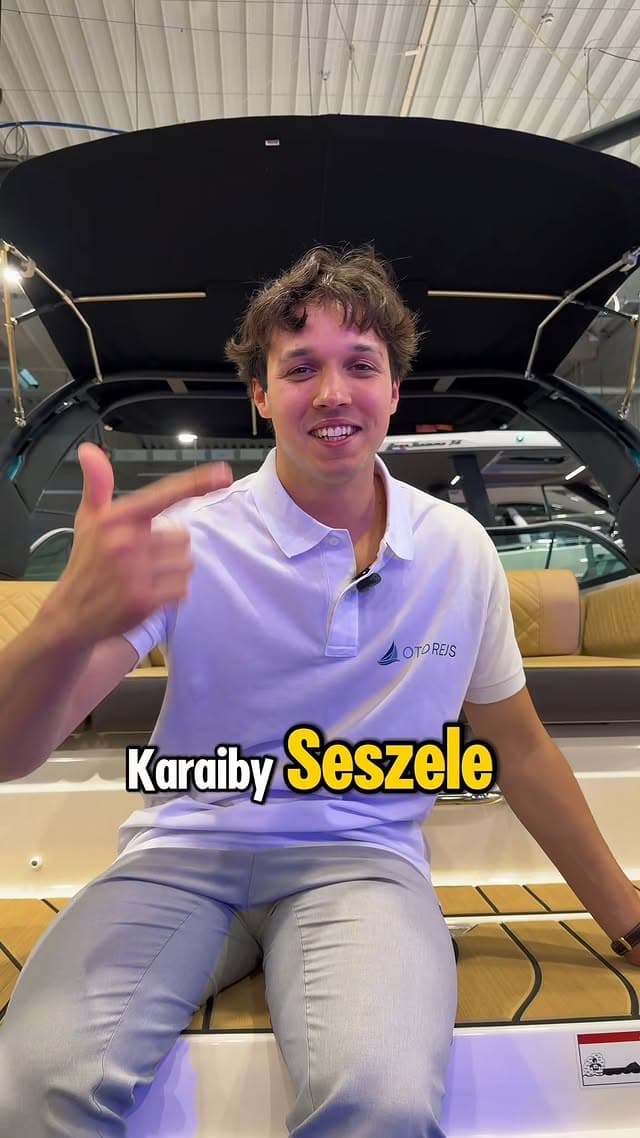 Przedstawiciel OtoRejs na rufie jachtu wskazuje napisy Karaiby i Seszele